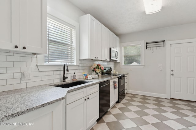 4534 College St, Jacksonville, FL 32205 - kitchen featuring black appliances, a sink, light floors, baseboards, and white cabinetry