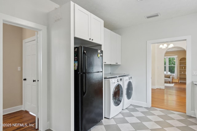 4534 College St, Jacksonville, FL 32205 - laundry room with arched walkways, washer and dryer, cabinet space, light flooring, and baseboards