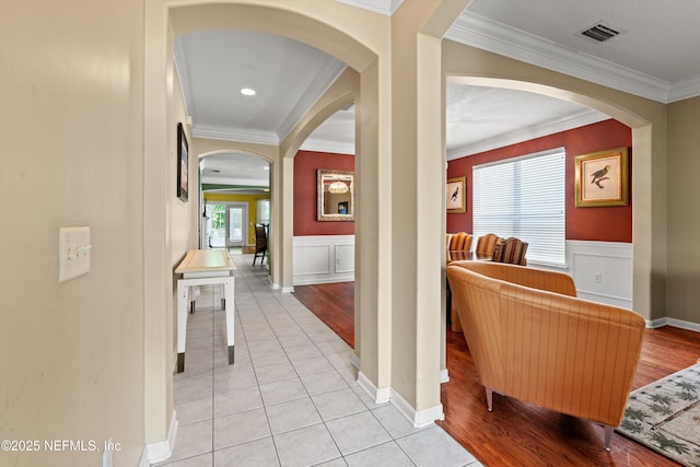 766 Candlebark Dr, Jacksonville, FL 32225 - hallway with arched walkways, ornamental molding, wainscoting, and light tile patterned flooring