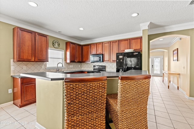766 Candlebark Dr, Jacksonville, FL 32225 - kitchen featuring black appliances, light tile patterned flooring, arched walkways, healthy amount of natural light, and crown molding