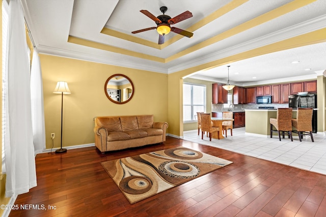 766 Candlebark Dr, Jacksonville, FL 32225 - living room featuring light wood-type flooring, a ceiling fan, baseboards, and crown molding