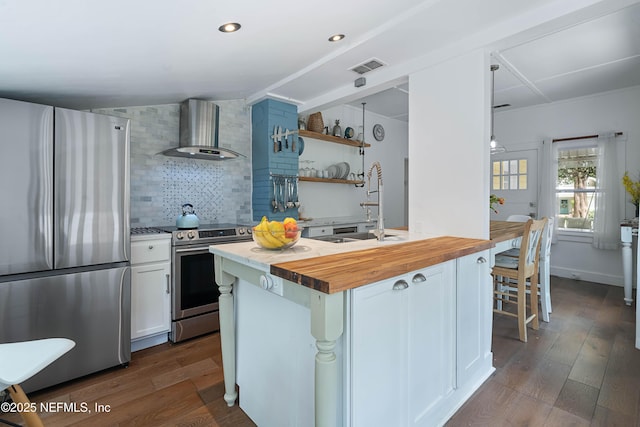 2720 Apache Ave, Jacksonville, FL 32210 - kitchen with visible vents, appliances with stainless steel finishes, a sink, butcher block counters, and wall chimney exhaust hood