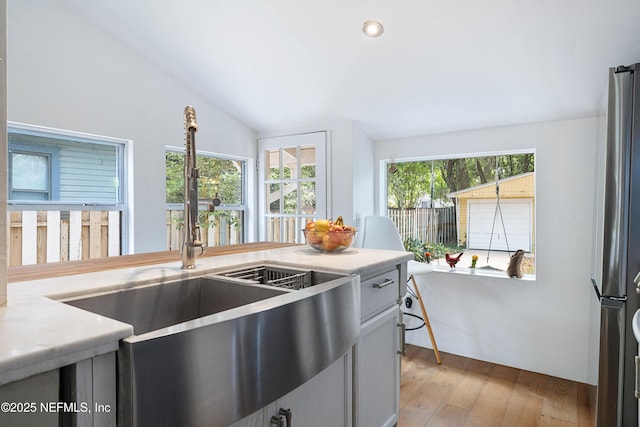 2720 Apache Ave, Jacksonville, FL 32210 - kitchen with light countertops, a sink, freestanding refrigerator, lofted ceiling, and light wood-style floors