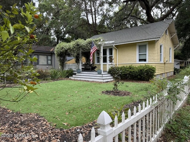 2720 Apache Ave, Jacksonville, FL 32210 - view of front facade featuring fence, roof with shingles, and a front lawn