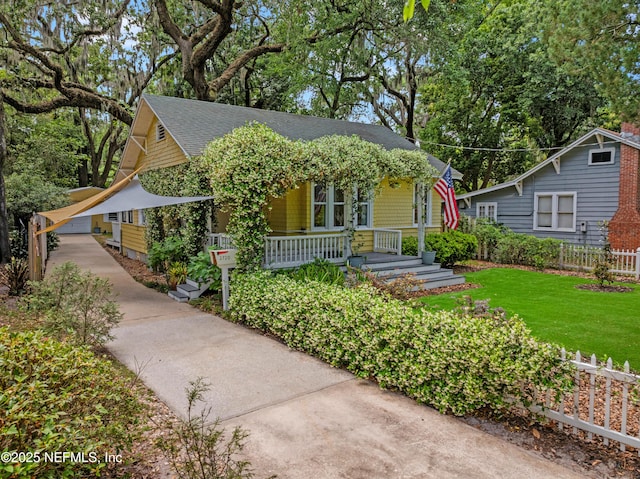 2720 Apache Ave, Jacksonville, FL 32210 - view of front of property with fence, a shingled roof, a front lawn, a porch, and driveway