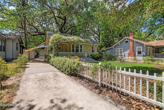 2720 Apache Ave, Jacksonville, FL 32210 - bungalow-style home with a garage, fence, covered porch, a chimney, and driveway