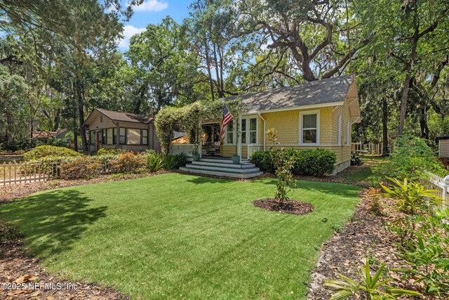 2720 Apache Ave, Jacksonville, FL 32210 - view of front of house with a shingled roof, a front lawn, and fence
