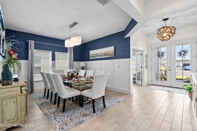 49 Golden Fern Dr, Saint Augustine, FL 32092 - dining space with a wainscoted wall, a chandelier, french doors, and visible vents