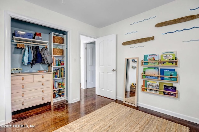 bedroom with baseboards, wood finished floors, and a closet