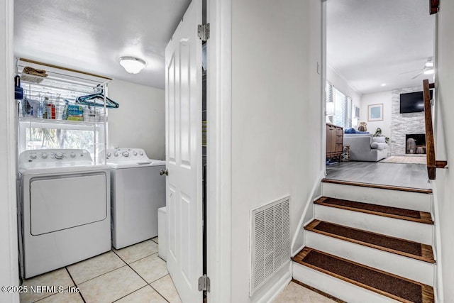 laundry room with ceiling fan, laundry area, separate washer and dryer, light tile patterned floors, and visible vents