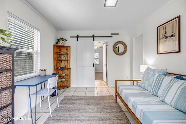 living room with light tile patterned flooring, visible vents, a barn door, and ornamental molding