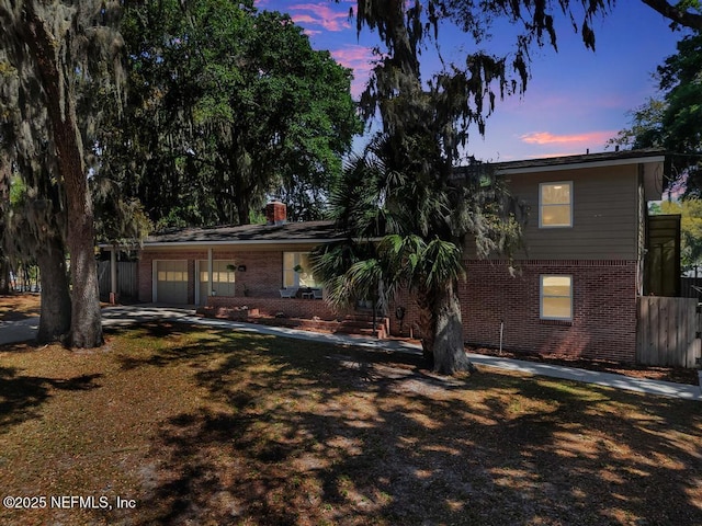 single story home featuring brick siding, fence, and a chimney