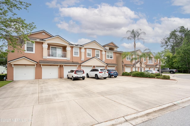 108 Brannan Pl Unit 103, Saint Johns, FL 32259 - view of front of property featuring driveway, stucco siding, an attached garage, a balcony, and a residential view