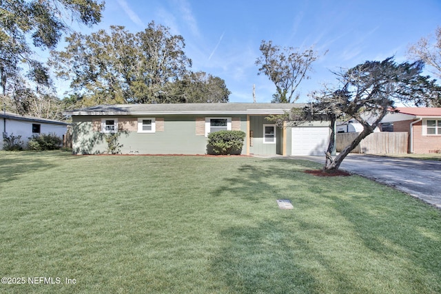 ranch-style home featuring fence, aphalt driveway, a front lawn, and a garage