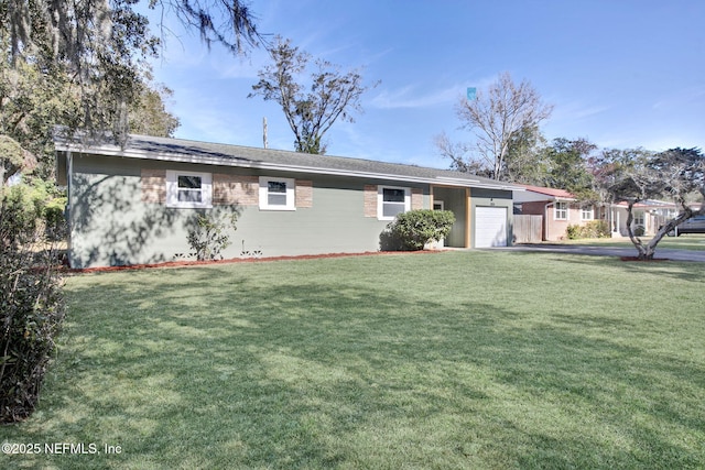 ranch-style house featuring brick siding, an attached garage, and a front lawn