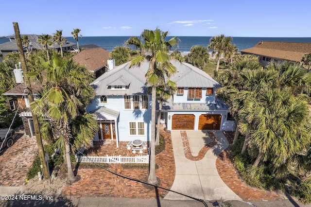 1057 Beach Ave, Atlantic Beach, FL 32233 - view of front of home with a water view, a garage, fence, metal roof, and driveway