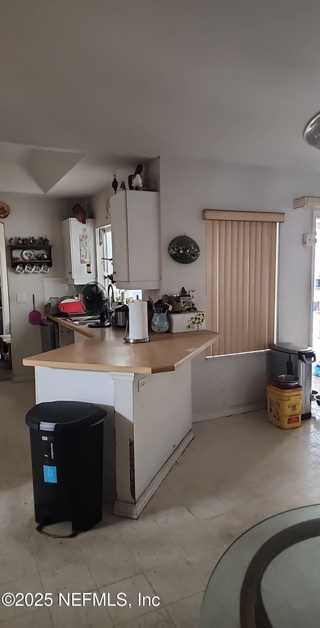 kitchen with a wealth of natural light, white cabinets, and a sink