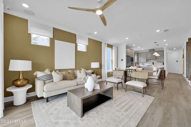 living area featuring plenty of natural light, ceiling fan, light wood-style floors, and recessed lighting