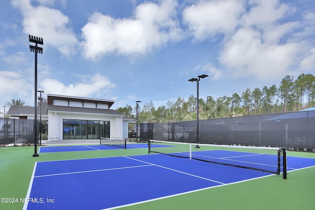 view of tennis court featuring fence and community basketball court