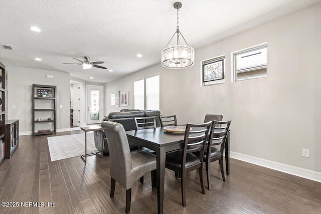 dining room with baseboards, ceiling fan with notable chandelier, and dark wood-style floors