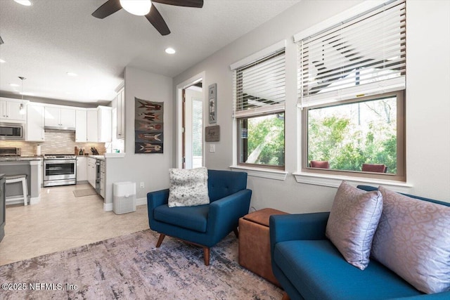 living room featuring recessed lighting, a ceiling fan, and light tile patterned floors