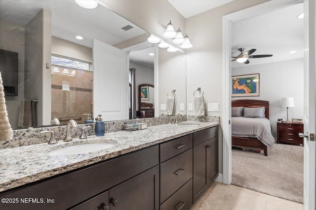 full bathroom with double vanity, ceiling fan, a sink, and ensuite bathroom