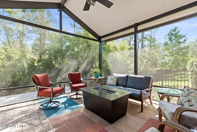 sunroom / solarium with a ceiling fan and an outdoor living space with a fire pit