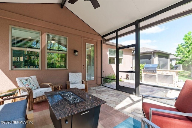 sunroom / solarium featuring a ceiling fan, area for grilling, and beamed ceiling