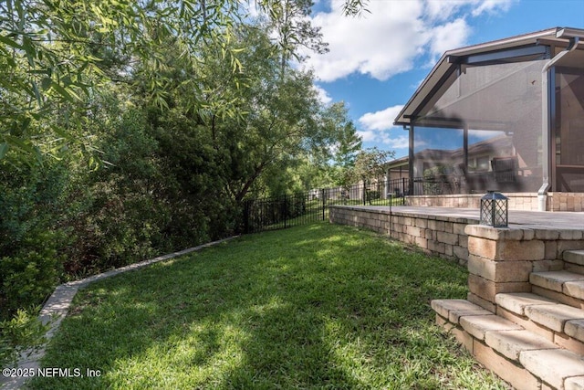 view of yard featuring fence and a sunroom