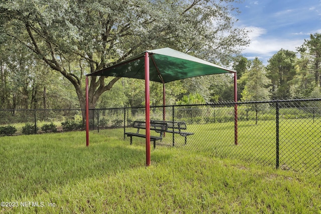 view of home's community featuring fence and a yard