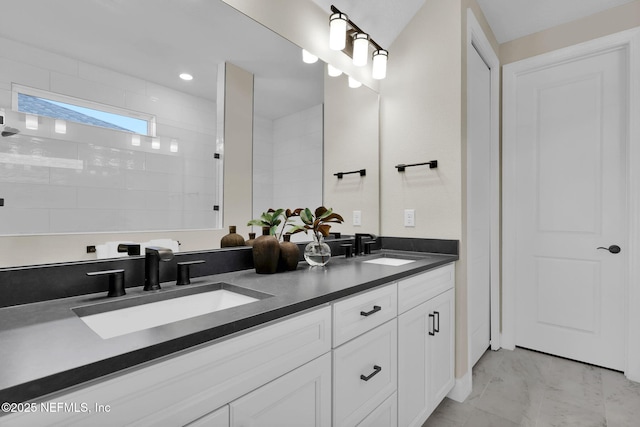 bathroom with double vanity, a sink, and a walk in shower