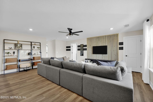 living area featuring a ceiling fan, recessed lighting, wood finished floors, and visible vents