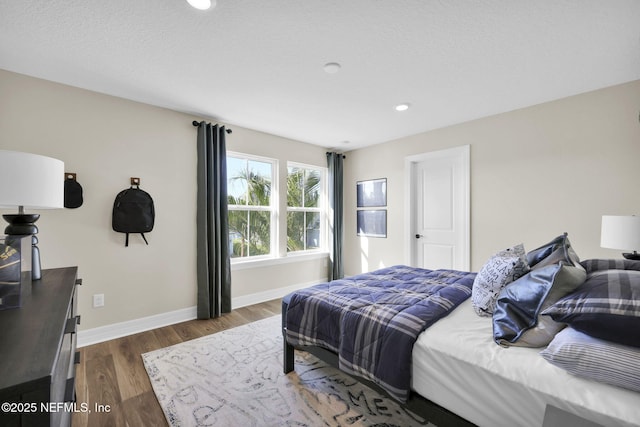 bedroom with recessed lighting, baseboards, and dark wood-style floors