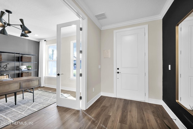 entrance foyer featuring crown molding, visible vents, wood finished floors, baseboards, and french doors