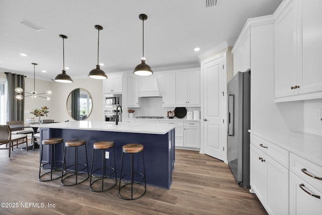 kitchen with visible vents, appliances with stainless steel finishes, premium range hood, dark wood-style floors, and white cabinetry