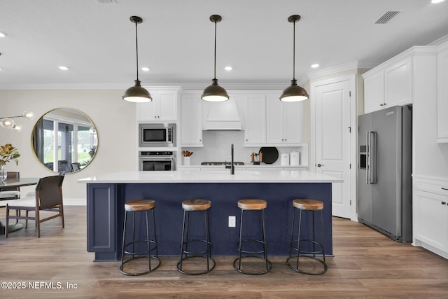 kitchen featuring light countertops, white cabinets, appliances with stainless steel finishes, and custom range hood