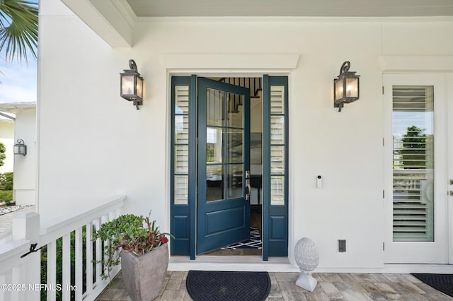 property entrance featuring a porch and stucco siding