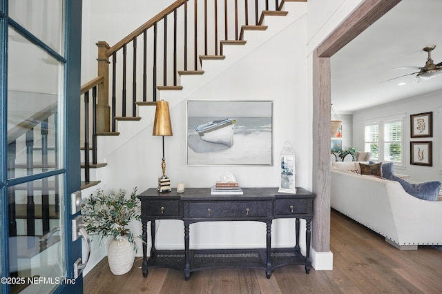 entrance foyer with a ceiling fan, wood finished floors, and stairway