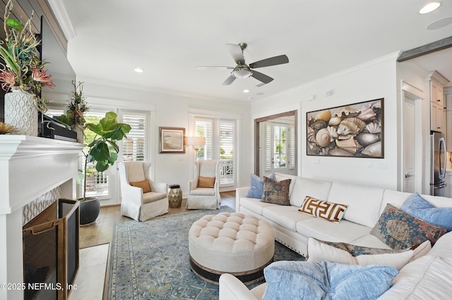 living area with recessed lighting, ornamental molding, ceiling fan, and a fireplace