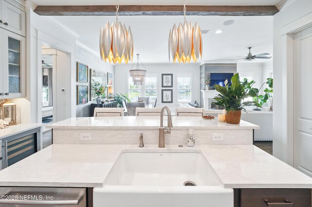 kitchen with stainless steel dishwasher, open floor plan, ceiling fan, light countertops, and a sink
