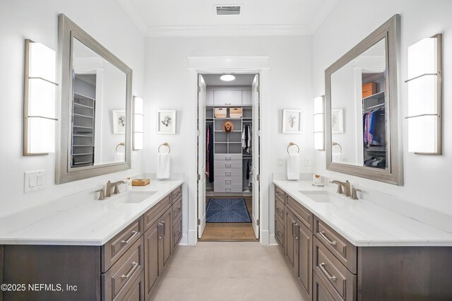 bathroom featuring a sink, ornamental molding, and visible vents