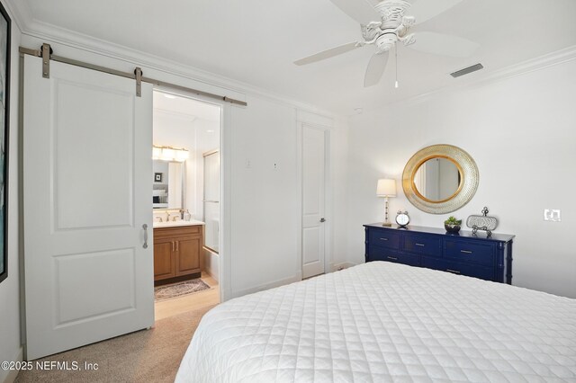 bedroom with crown molding, visible vents, a barn door, and ensuite bathroom