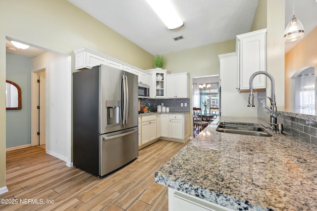 12139 Cap Ferrat St, Jacksonville, FL 32224 - kitchen with a sink, visible vents, light wood finished floors, backsplash, and appliances with stainless steel finishes