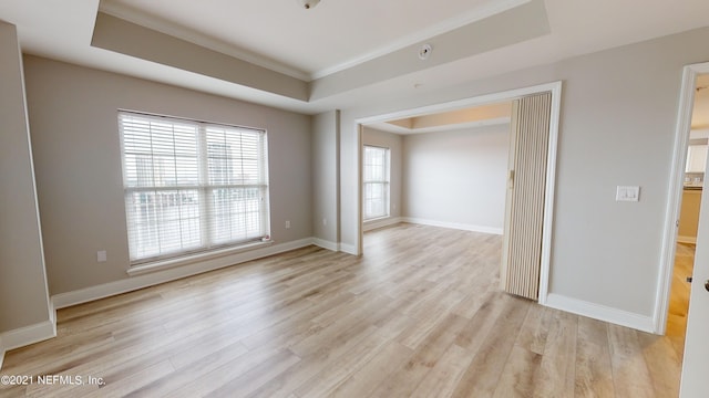 400 E Bay St Unit 1610-1611, Jacksonville, FL 32202 - spare room featuring light wood-style floors, baseboards, ornamental molding, and a tray ceiling