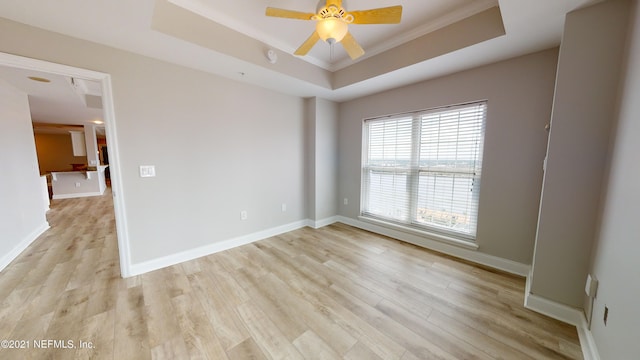 400 E Bay St Unit 1610-1611, Jacksonville, FL 32202 - spare room featuring ornamental molding, baseboards, ceiling fan, a tray ceiling, and light wood-style flooring