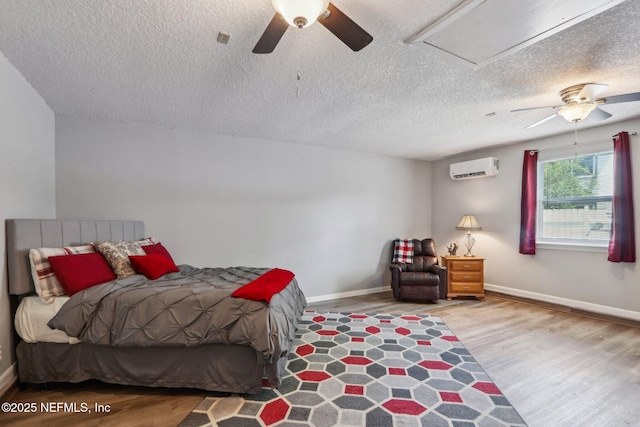 5914 Orchard Pond Dr, Fleming Island, FL 32003 - bedroom with wood finished floors, a wall unit AC, a textured ceiling, and baseboards