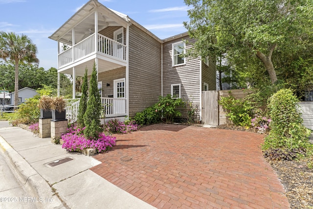 120 Washington St, Saint Augustine, FL 32084 - view of front facade featuring fence, a balcony, and covered porch
