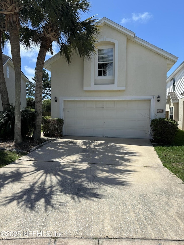 view of home's exterior with stucco siding and concrete driveway