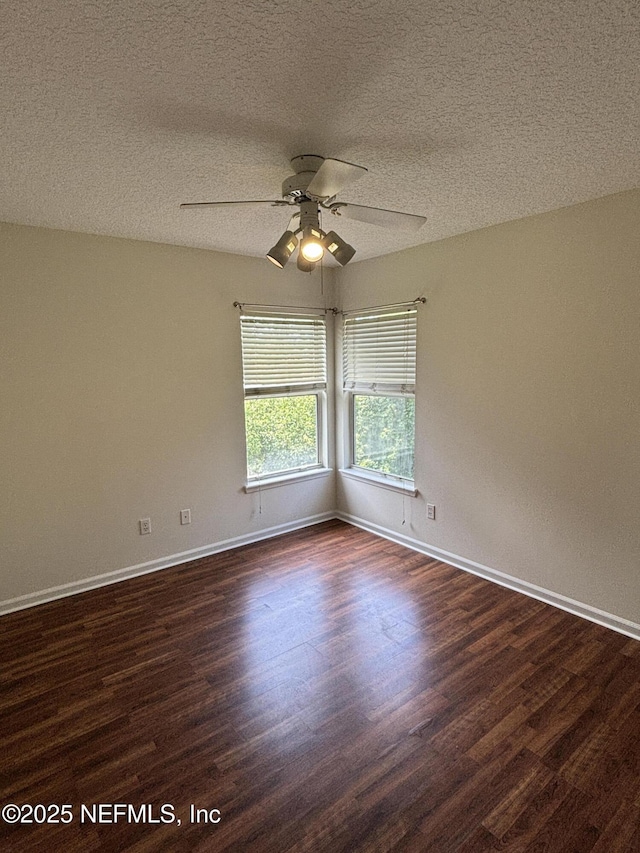 unfurnished room featuring a ceiling fan, a textured ceiling, dark wood finished floors, and baseboards