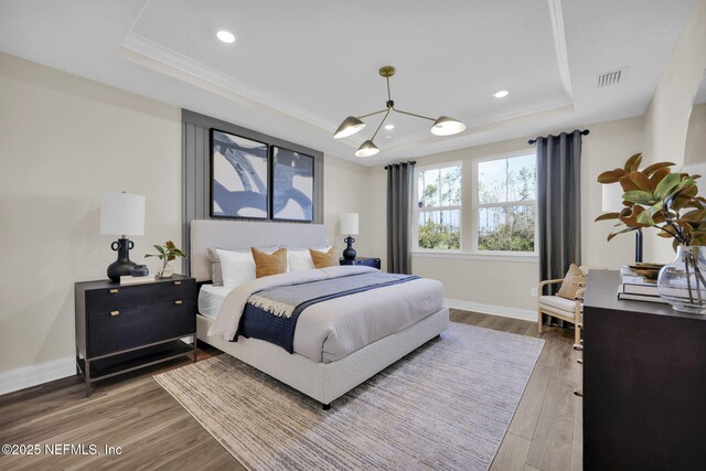 568 Blind Oak Cir, Saint Augustine, FL 32095 - bedroom with baseboards, a tray ceiling, wood finished floors, and visible vents